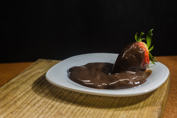 postre fresa con chocolate en plato blanco