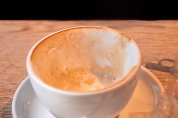 empty and dirty cups of coffee after breakfast. Dirty coffee cups with milk foam. Mess on the table after breakfast with dirty mug. Afterparty. White porcelain cup with leftover cappuccino. 