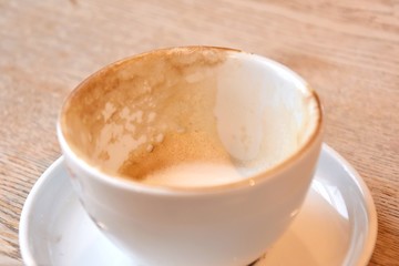empty and dirty cups of coffee after breakfast. Dirty coffee cups with milk foam. Mess on the table after breakfast with dirty mug. Afterparty. White porcelain cup with leftover cappuccino. 