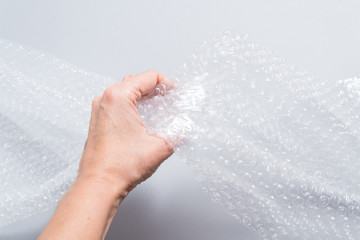 Fototapeta premium Hand holding packaging material, bubble film