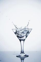 Clear mineral water is poured into a glass with ice.