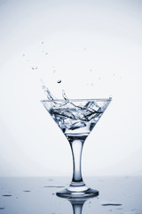 Clear mineral water is poured into a glass with ice.