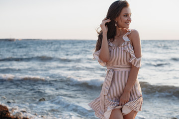 Beautiful young woman posing against the sea and skyline.Happy woman relaxing near the sea on...