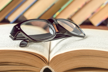 Glasses for vision lie on an open book, general education concept