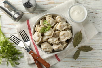 Composition with dumplings, towel and spices on wooden background, top view