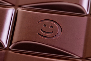 Texture of the  dark chocolate bar with smile from top view