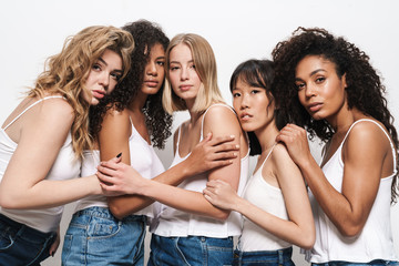 Image of beautiful multinational women posing and hugging together