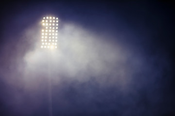 stadium lights and smoke against dark night sky background