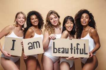 Image of young multinational women smiling and holding placards