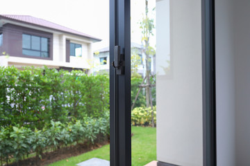 security lock on glass window with green garden outside view of home