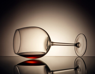 Kieliszek wina leży na szkle z odrobiną wina