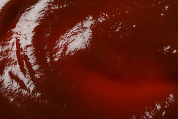 Barbecue sauce textured background, top view, closeup. Space for text