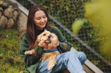 woman with american cocker spaniel walks at autumn park