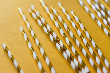 gold and white eco paper drinking straws on yellow background