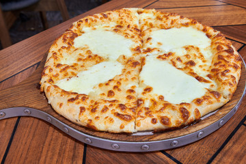 Georgian traditional dish khachapuri on the wooden table. Bakery product filled and covered with cheese. Caucasian cuisine.