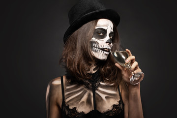 Halloween girl with skull makeup for Halloween on a black background