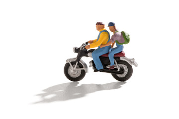 Fototapeta na wymiar Two miniature men on motorbike on white