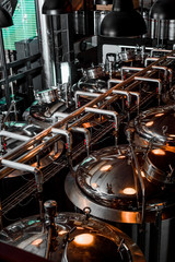 Large reservoirs, tanks and pipes with manometers in private microbrewery. Craft beer production...