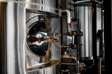Large reservoirs, tanks and pipes with manometers in private microbrewery. Craft beer production...