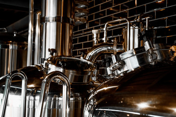 Large reservoirs, tanks and pipes with manometers in private microbrewery. Craft beer production...