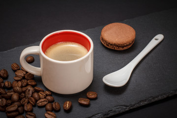 Cup of coffee and coffee beans on black background