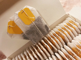 Two tea bags with yellow labels.
