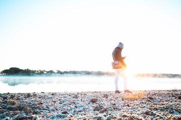 Man watching his phone in sunrise