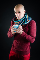 Young attractive guy is drinking a hot drink. 