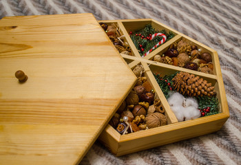 Gift nut set in a wooden box with a lid. for Christmas and New Year. Christmas-tree cones and branches. Lollipop. cotton. 