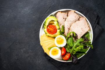 Keto diet plate on black stone table.