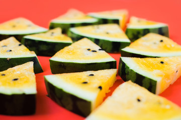 cut off triangular slices of ripe yellow watermelon on white background