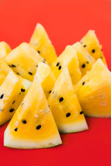 cut off triangular slices of ripe yellow watermelon on white background