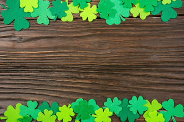 Happy Saint Patrick's mockup of handmade felt shamrock clover leaves on wooden background.