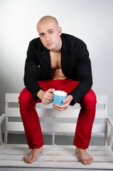 Young attractive guy is drinking a hot drink.