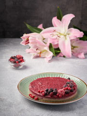 Raw vegan berry cherry cheesecake gluten-free on grey background.