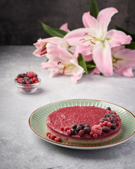 Raw vegan berry cherry cheesecake gluten-free on grey background.