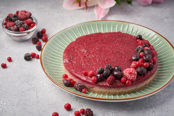 Raw vegan berry cherry cheesecake gluten-free on grey background.