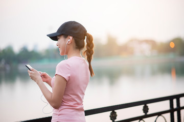 Beautiful woman is listening music in the park