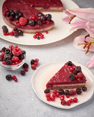 Raw vegan berry cherry cheesecake gluten-free on grey background.