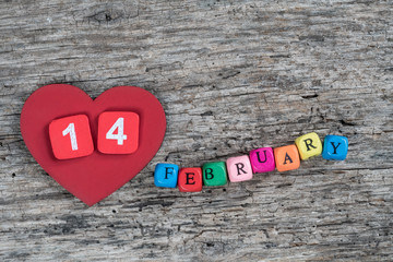 colorful cube calendar and heart on wooden background for february