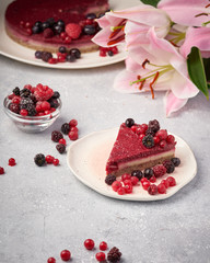 Raw vegan berry cherry cheesecake gluten-free on grey background.
