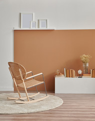 Brown and white wall background, chair frame book and vase of plant in the room.