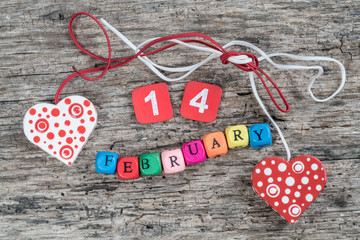 February cube calendar and hearts on wooden background for valentines day