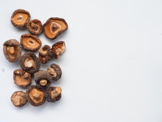 Dried Shiitake Mushrooms on white wooden table, is an edible mushroom native to East Asia, Mushroom is cultivated and consumed in many Asian countries. It is considered a medicinal mushroom.