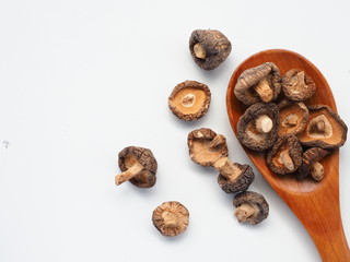 Dried Shiitake Mushrooms on wooden spoon on white wooden table, is an edible mushroom native to East Asia, Mushroom is cultivated and consumed in many Asian countries.