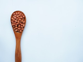 Peanut beans on white wooden background, is a legume crop grown mainly for its edible seeds.