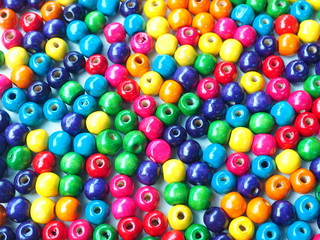 Multicolored wooden beads on a white wooden background, Can use as background or wallpaper.