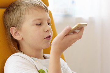 boy makes voice search on the smartphone, phone and gadget addiction