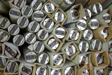 Fluorescent tube light. Many old spoiled, glass fluorescent lamps are in paper packaging for...