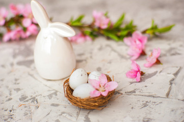 Obraz na płótnie Canvas Spring conceptual photo with flowers. Flat lay blooming tree, easter eggs. The tree blooms pink and the eggs in the nest and copy space.